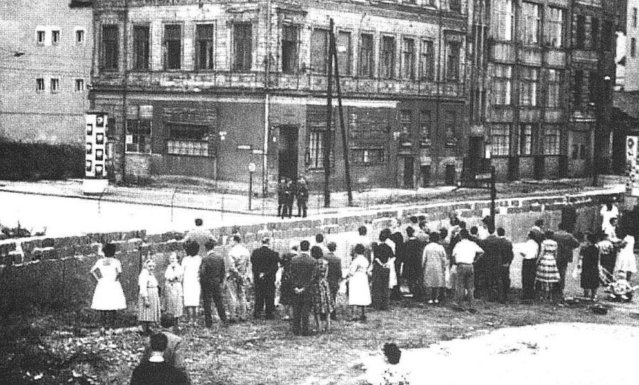 Habitantes da Berlim Ocidental observam o Muro nascente, com militaresd da Alemanha Oriental a postos no lado oposto