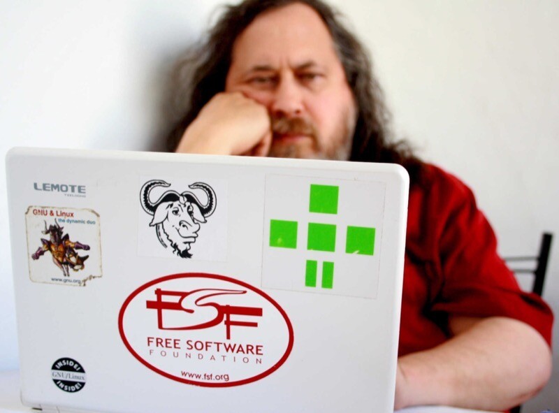 Richard Stallman e um notebook com adesivos do GNU