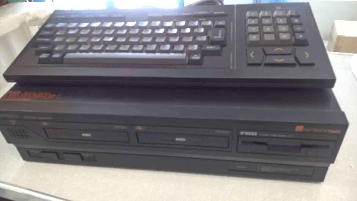 Um Expert DD Plus, em cor preta e com um drive de disquete ao lado dos slots.