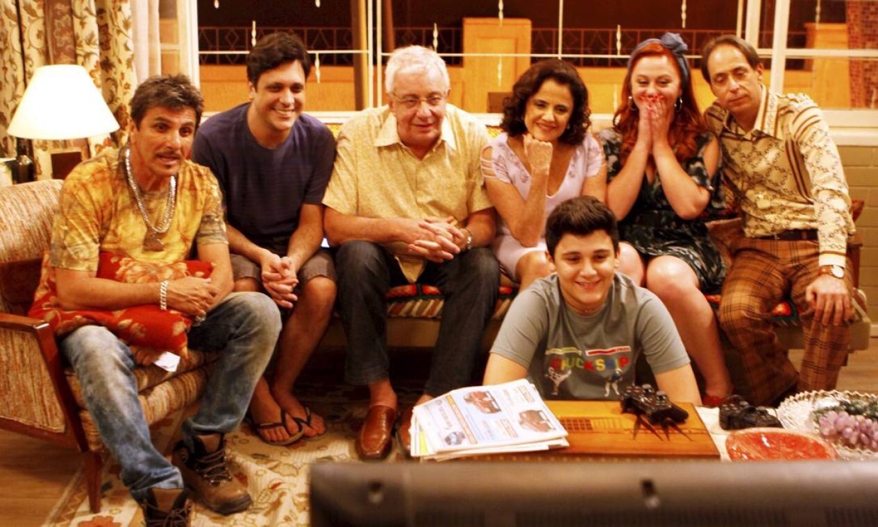 Elenco de A Grande Família reunido no sofá, com Lineu e Dona Nenê ao centro