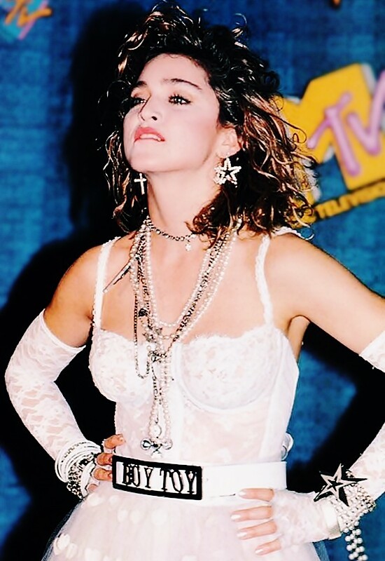 Madonna morde o lábio no MTV VMA de 1984, com figurino de noiva e o cinto com fivela escrita “Boy Toy“