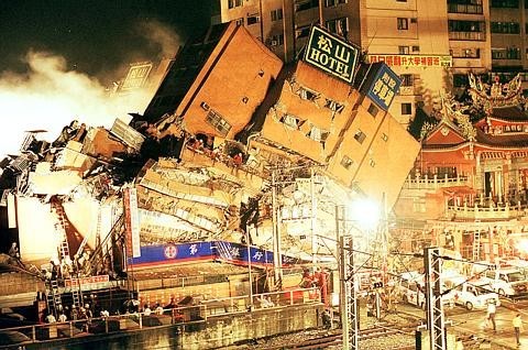 Foto mostra escombros de prédio tombado após o terremoto