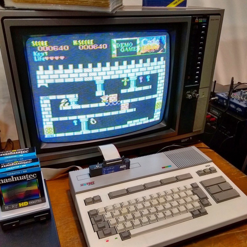 Um Hotbit, modelo branco, conectado a uma TV e jogando The Castle