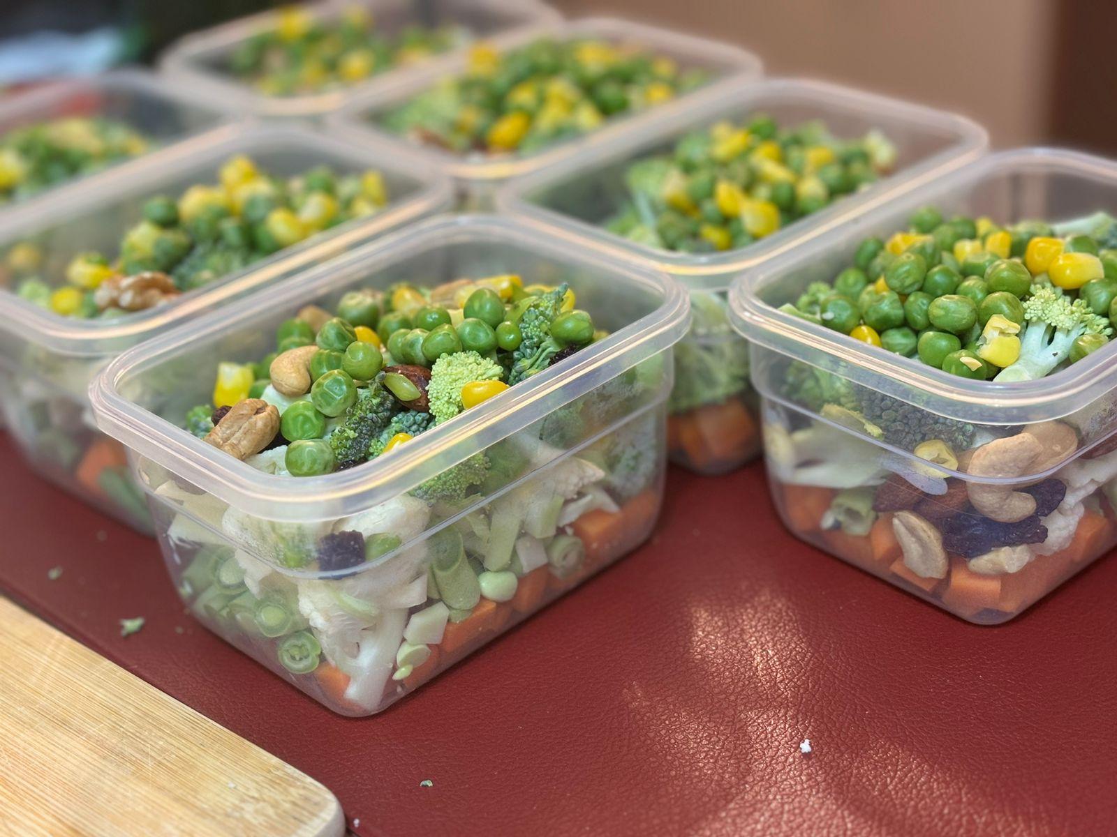 7 potinhos herméticos, ainda sem tampa, cada um contendo um mesmo mix de cenoura, vagem, brócolis, couve-flor, castanhas, ervilhas e milho
