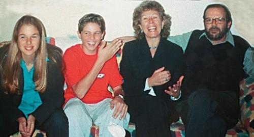 O casal Richthofen posa para foto sorridente no sofá ao lado da filha e do filho