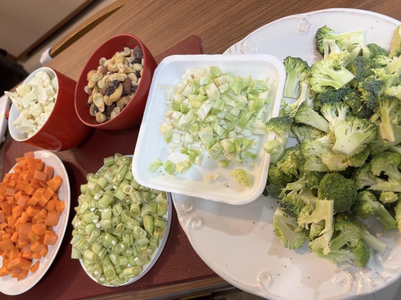 Os legumes picados, antes de serem colocados nos potes herméticos. Há grupos em separado para: brócolis, couve-flor, vagem, cenoura, castanhas, e um potinho com os talos da couve-flor e do brócolis, picados em cubinhos.