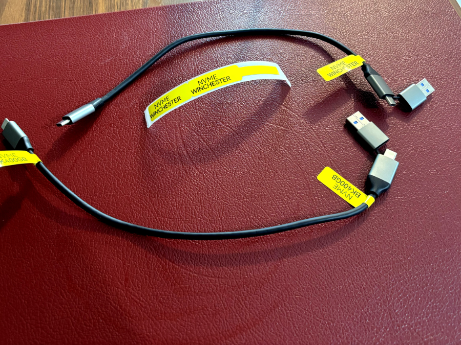 Dois cabos USB, identificados com etiquetas adesivas amarelas indicando os nomes dis discos externos conectados a eles: BKP400GB e Winchester.