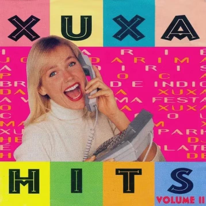 Capa de uma das edições do disco do programa Xuxa Hits, com foto da apresentadora, sorridente, segurando em suas mãos um telefone fixo.