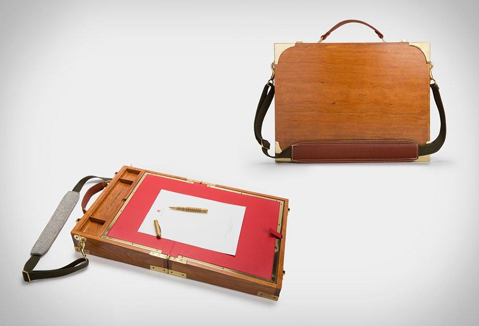 Duas fotos comerciais de um produto em forma de maleta com exterior em madeira, com aspecto clássico, que quando aberta se transforma em um tampo de mesa de trabalho.