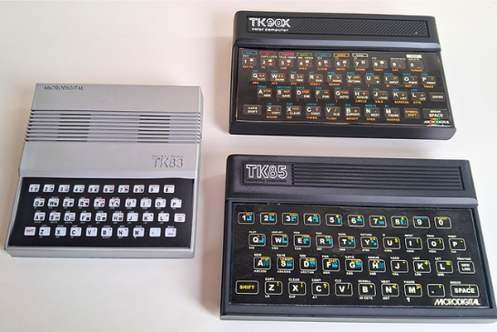 Foto mostrando um TK83, um TK85 e um TK90X, lado a lado em uma mesa.