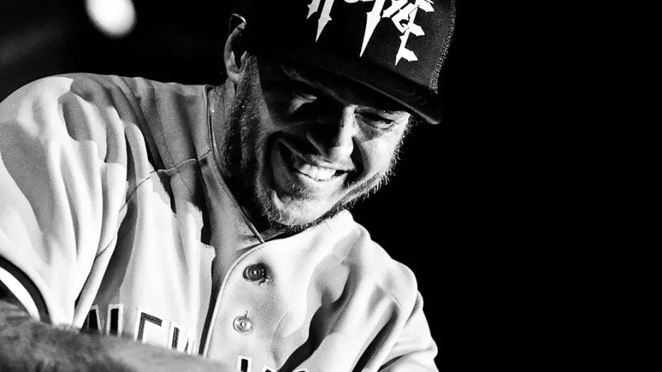 Chorão sorrindo em foto preto e branco.