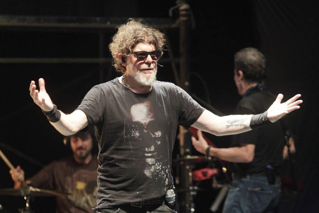 Foto de Branco Mello no palco, com os braços abertos