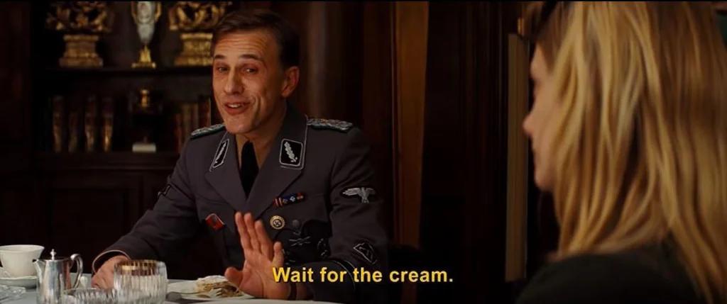 Cena do filme Bastardos Inglórios em que o coronel nazista Hans Landa, sorridente, diz para sua vítima, Shosanna, para esperar pelo creme antes de comer seu apfelstrudel