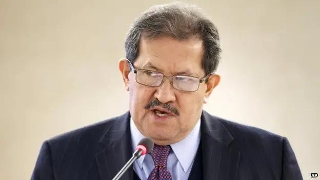 Foto jornalística de Garzon, de paletó e gravata, discursando em evento.