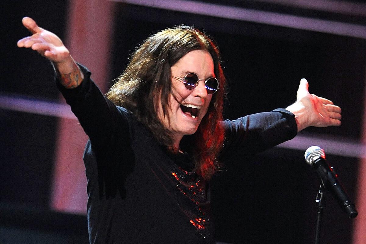 Foto de Ozzy Osbourne com os braços abertos e sorridente