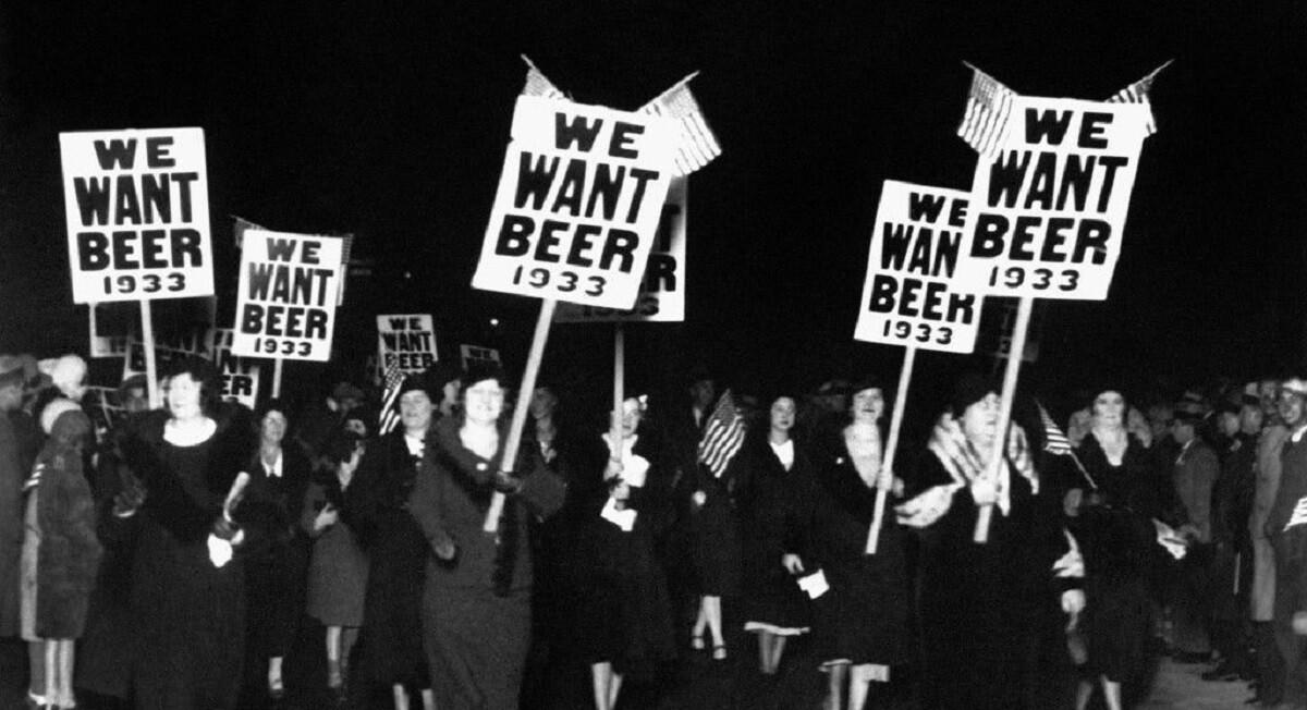 Cartazes 'We Want Beer - 1933' em foto preto e branco de passeata