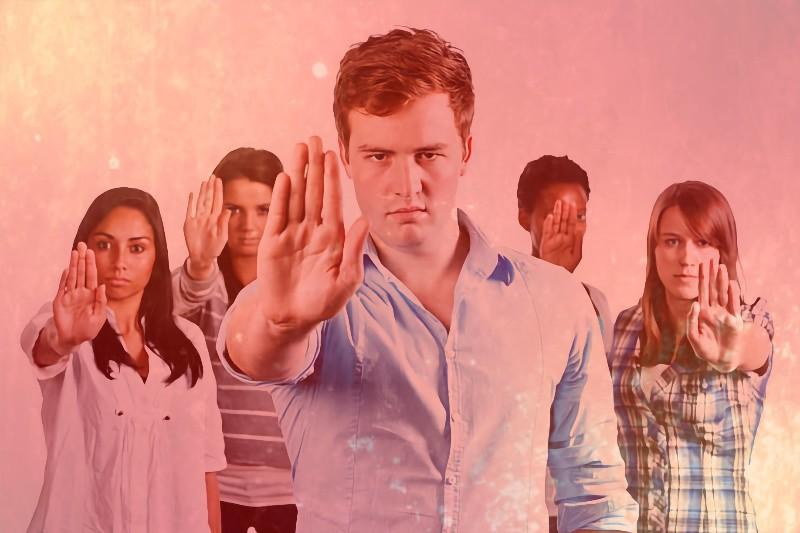 Grupo de pessoas fazendo o sinal de “pare“ com as mãos